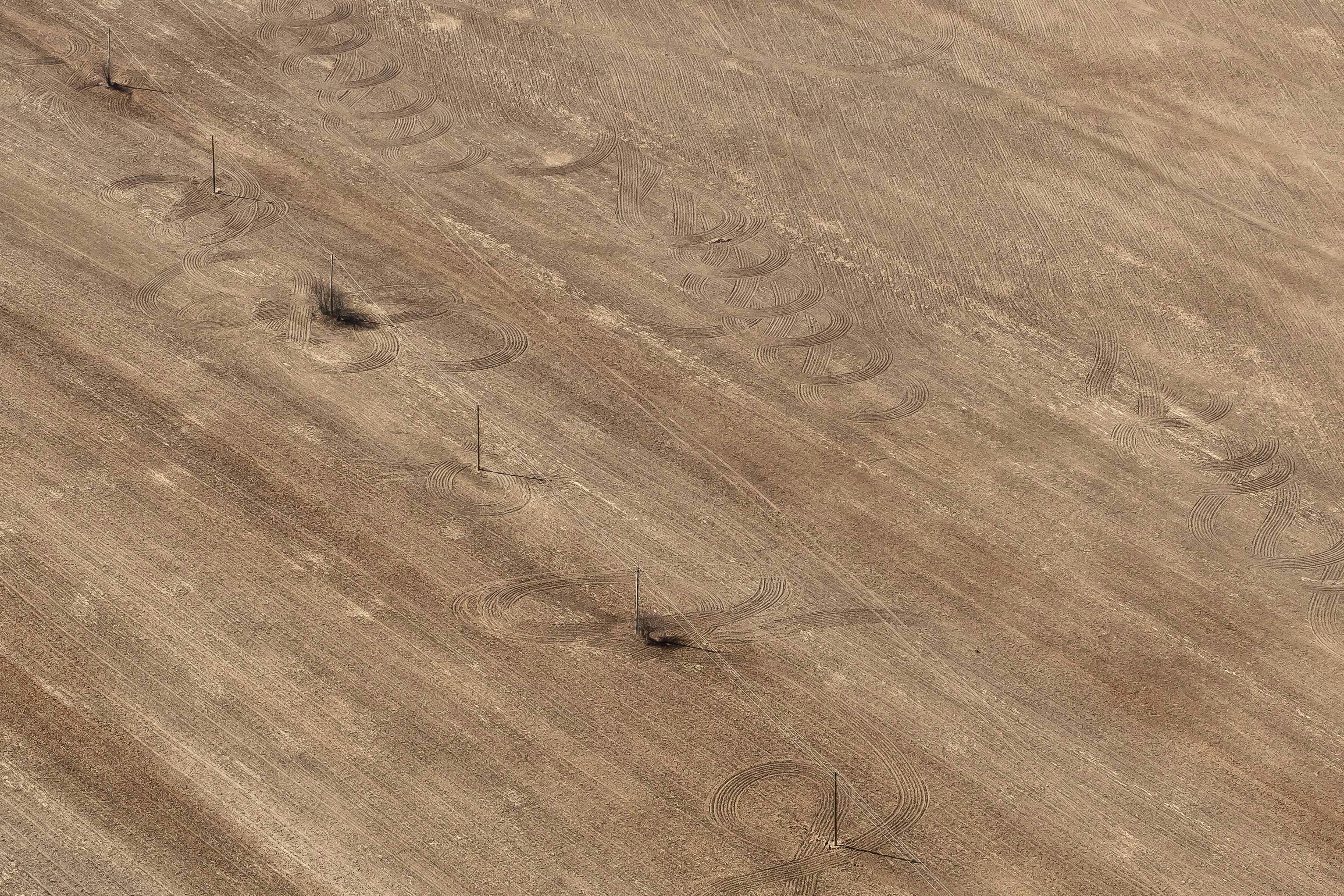 aerial photo of brown field with electric line